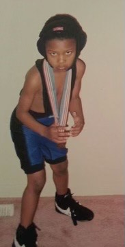 a young brandon with a wrestling medal around his neck poses for the camera