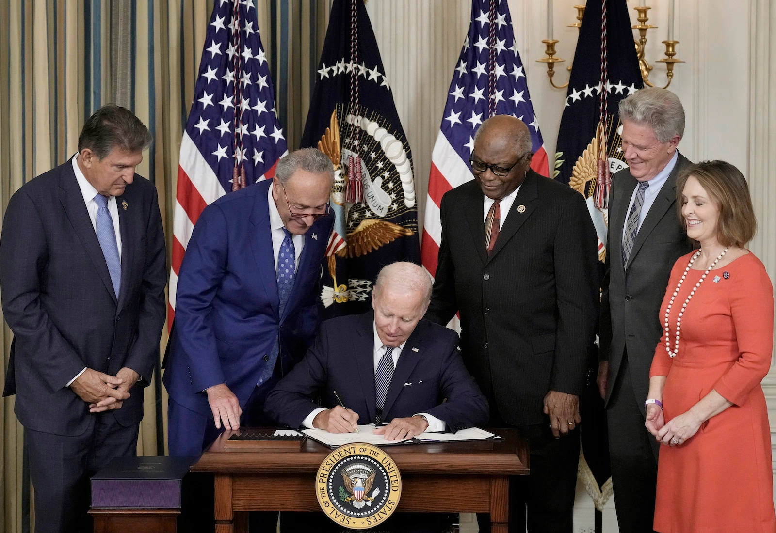 president joe biden signs the inflation reduction act, surrounded by white house officials