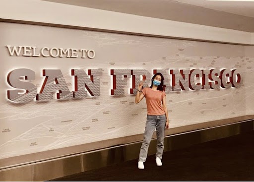 skyler li, a woman standing in front of a "San Francisco" sign, holidng up a peace sign as she embarks on her AmeriCorps service term