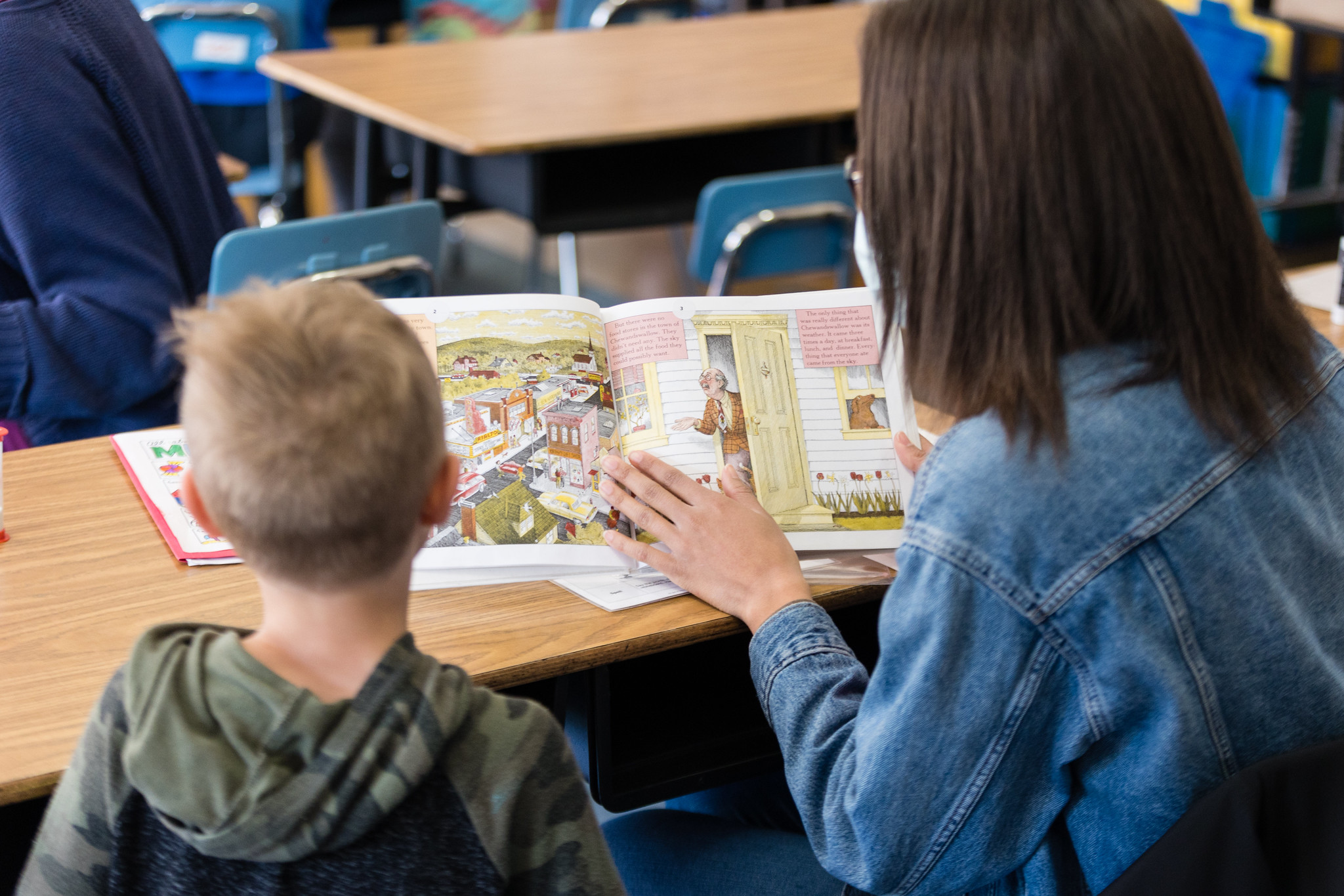 a tutor and student read together at a desk, balanced literacy