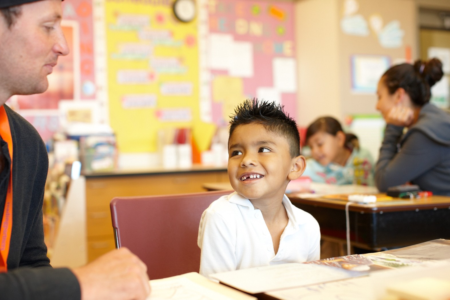 a young male student gazes up at his tutor with admiration, high-quality pre-k