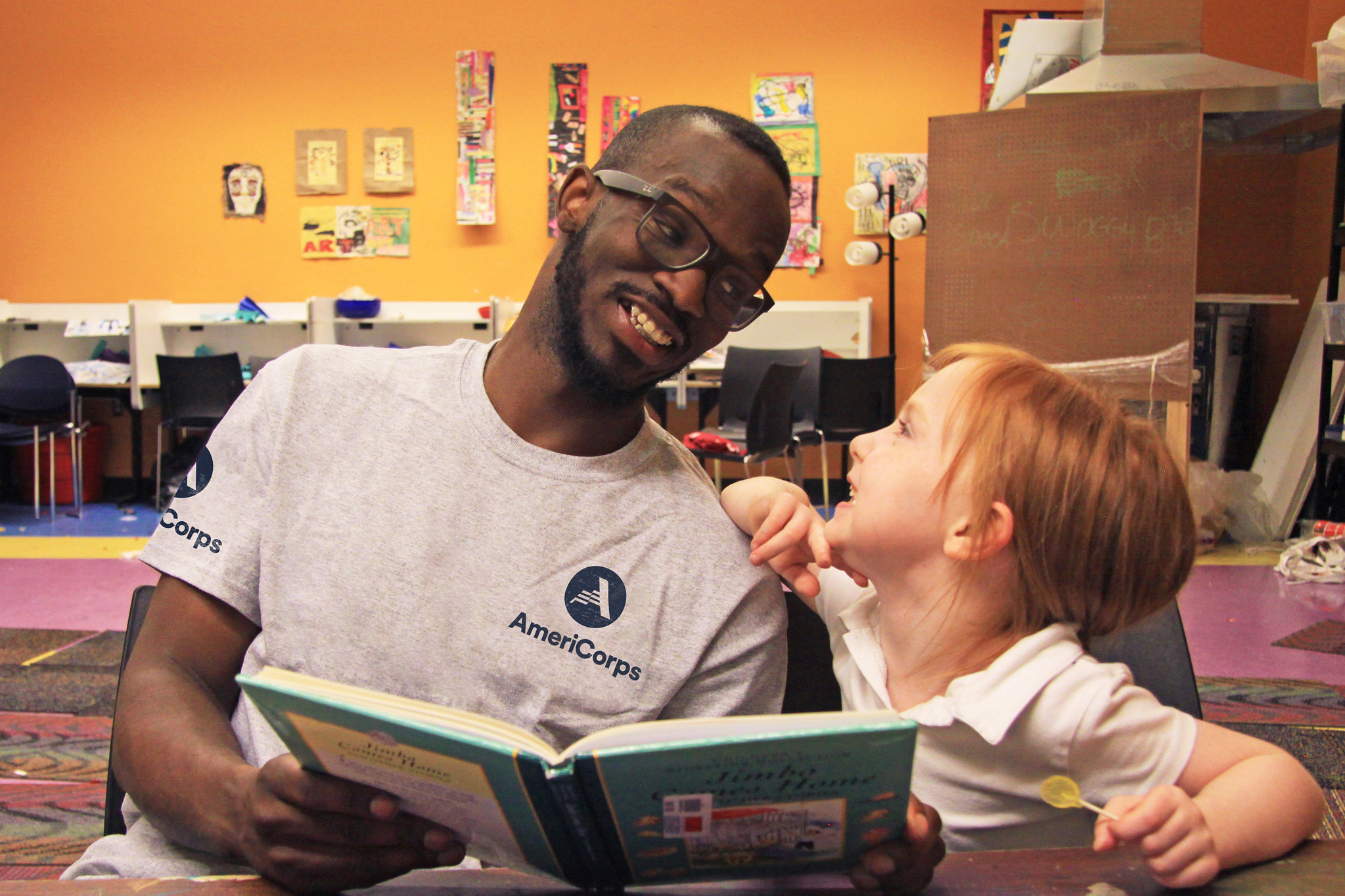 an americorps member and student smile while looking at each other