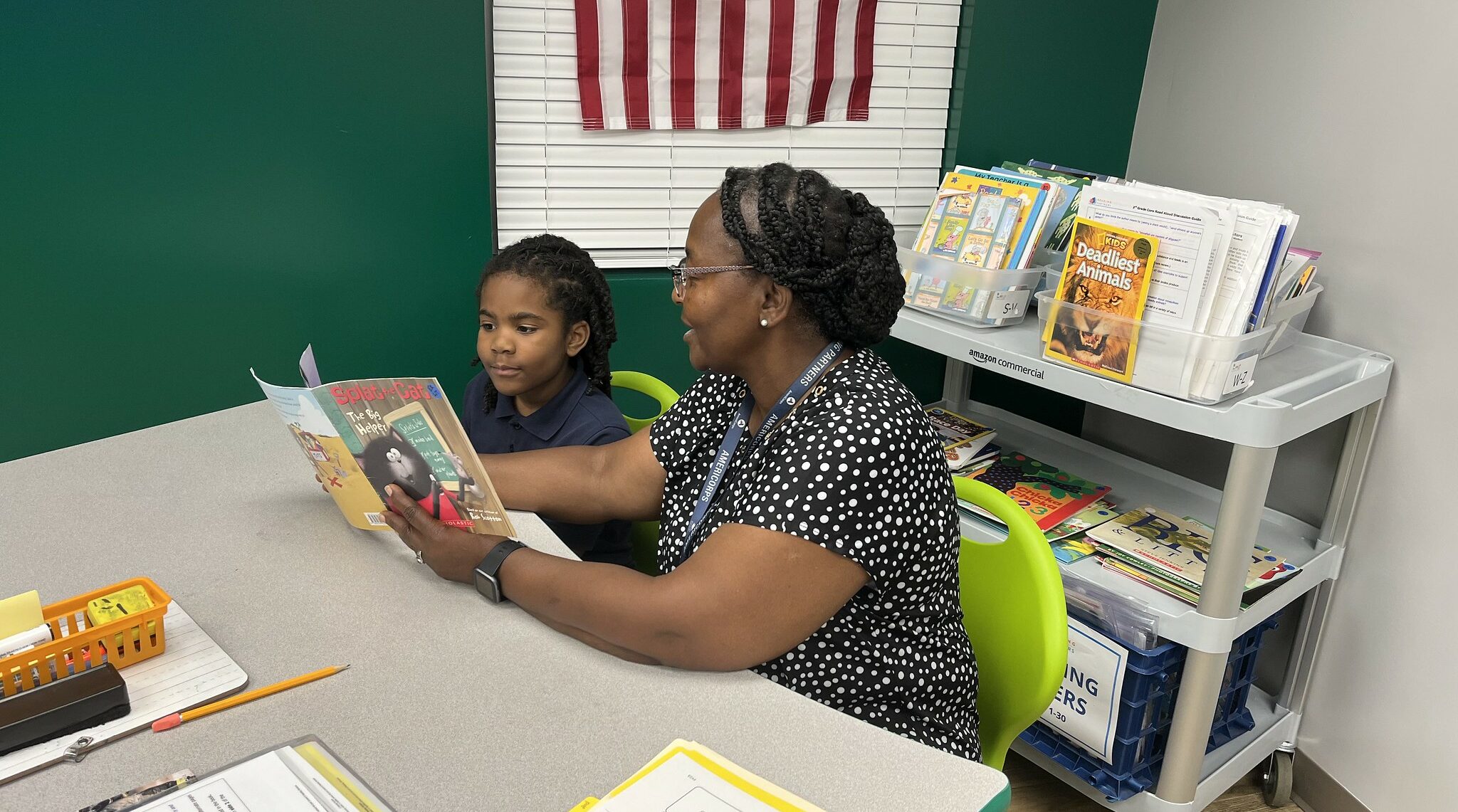 lifelong educational impact; an americorps member and student read a book together