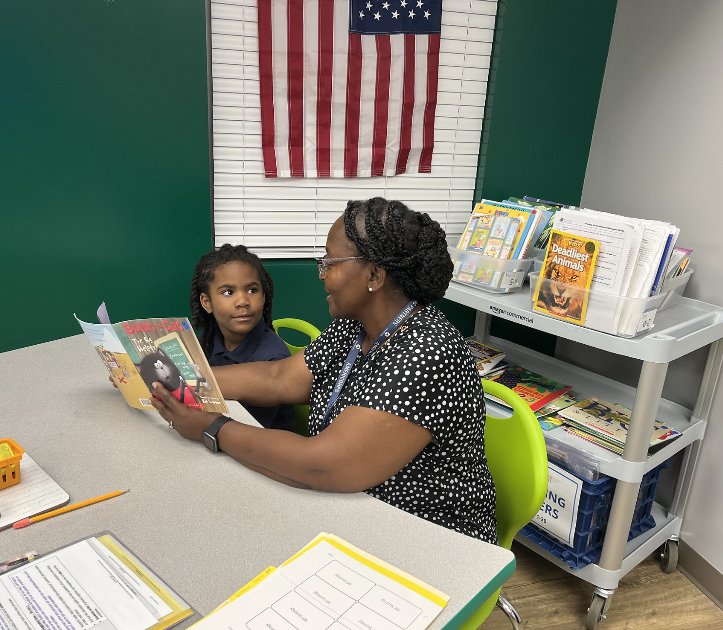 reading partners is ramping up innovation; a student gazes at his americorps program coordinator as she reads to him