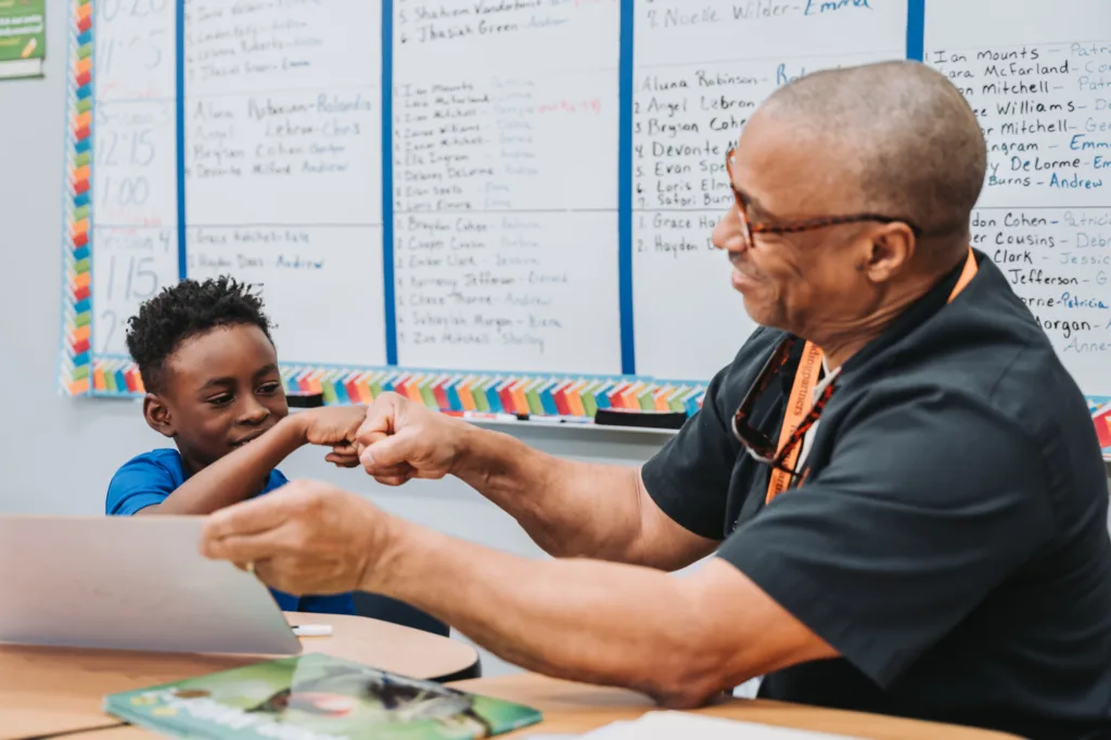 a tutor fighting off the loneliness epidemic by volunteering his time and fist-bumping a student