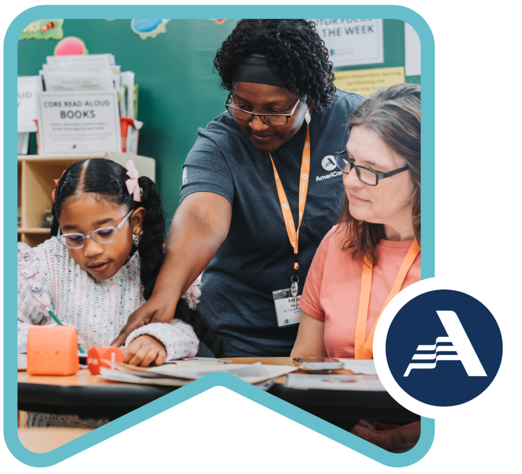 an americorps member pointing to a part of the literacy lesson that a tutor and student are working on