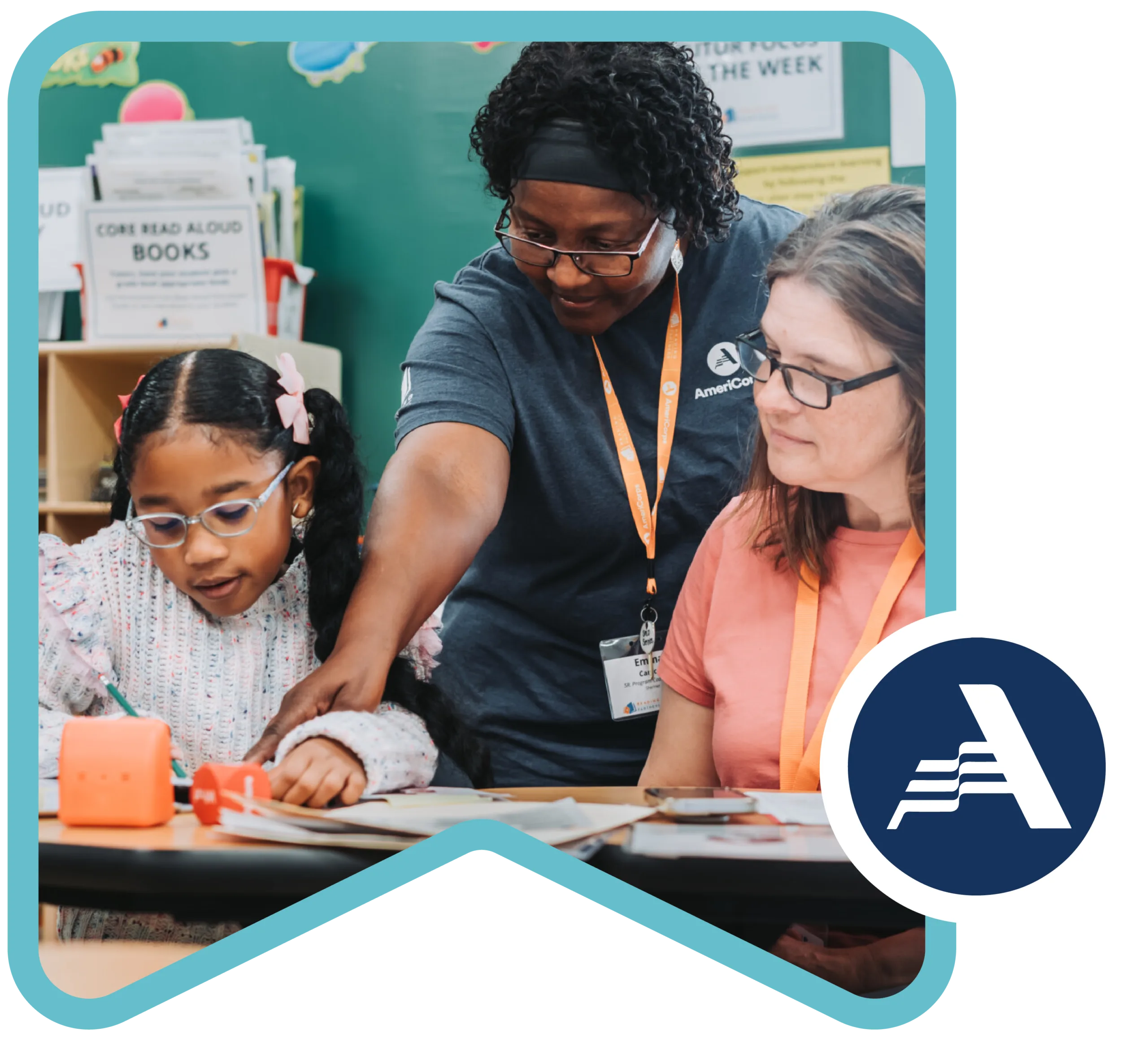 an americorps member pointing to a part of the literacy lesson that a tutor and student are working on