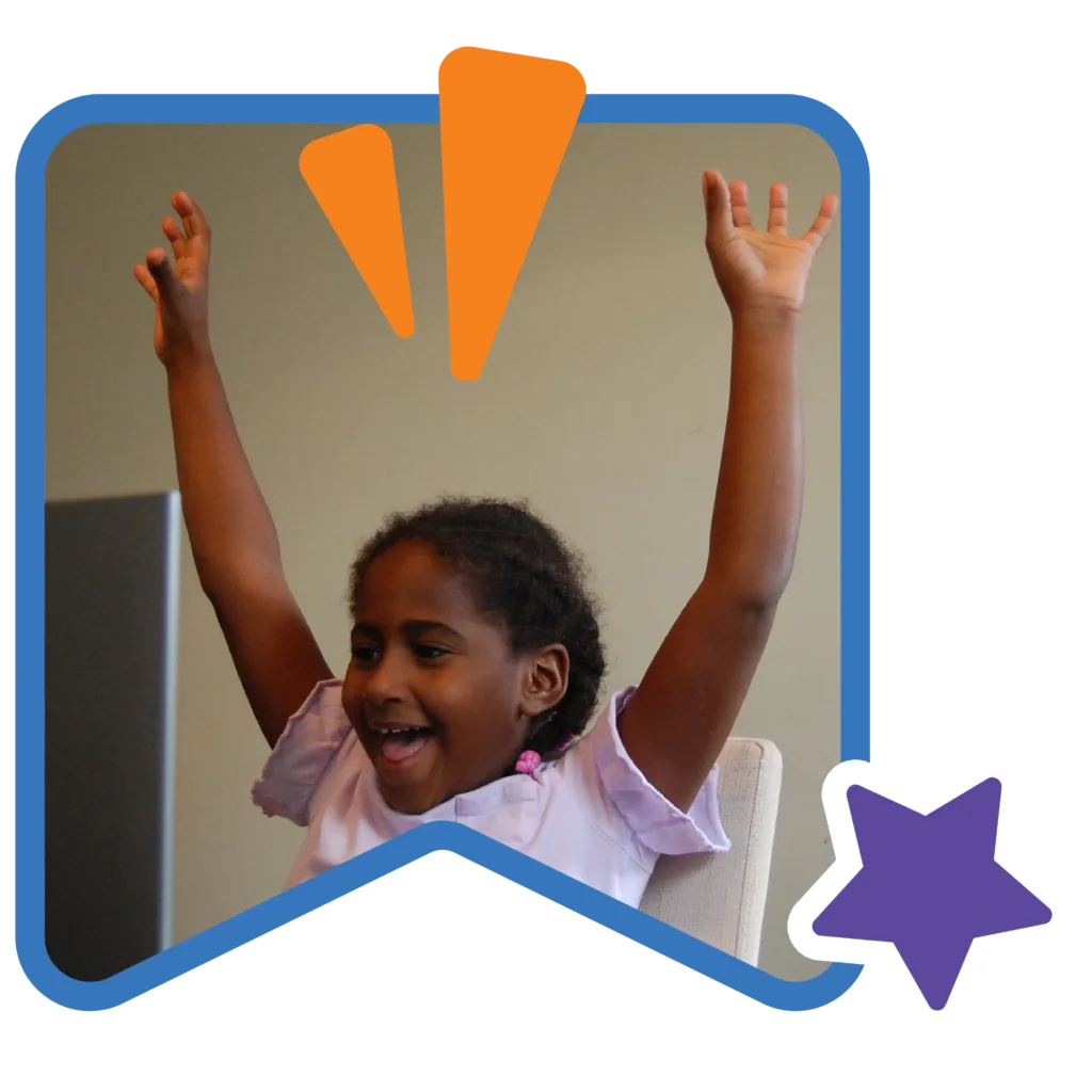 a student with her hands raised, looking excited at the laptop in front of her