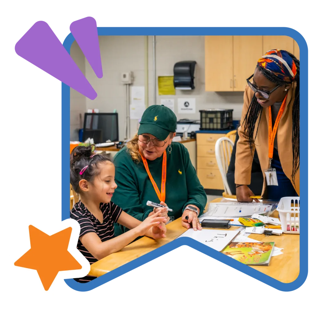 an americorps member oversees a student-tutor pair during their literacy lesson
