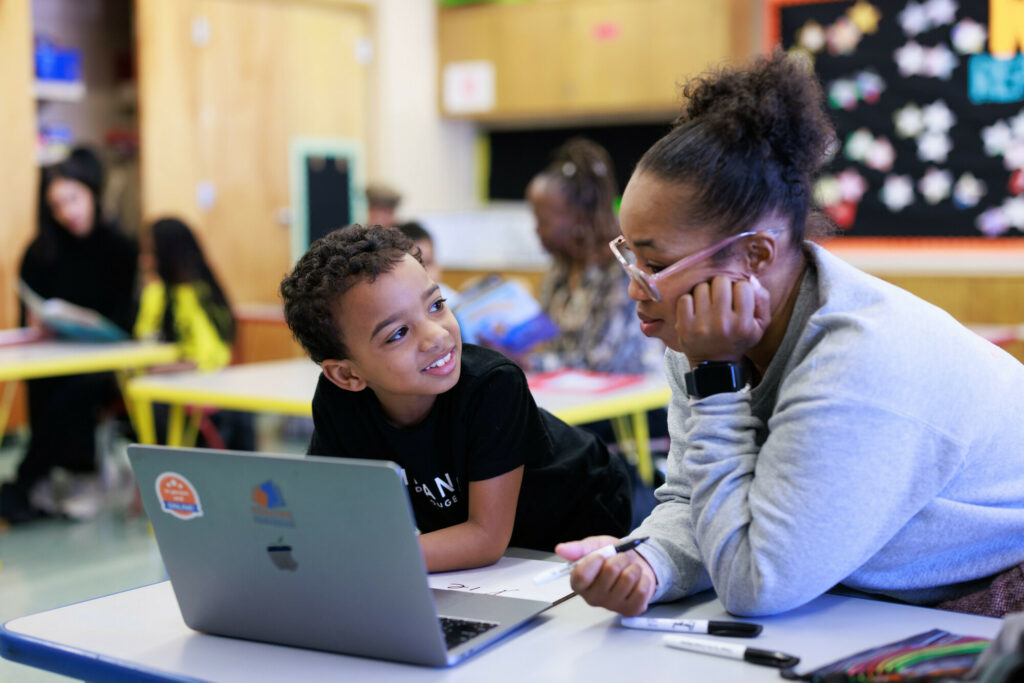 a tutor-student pair using reading partners connects, our innovation, on a computer in a reading center