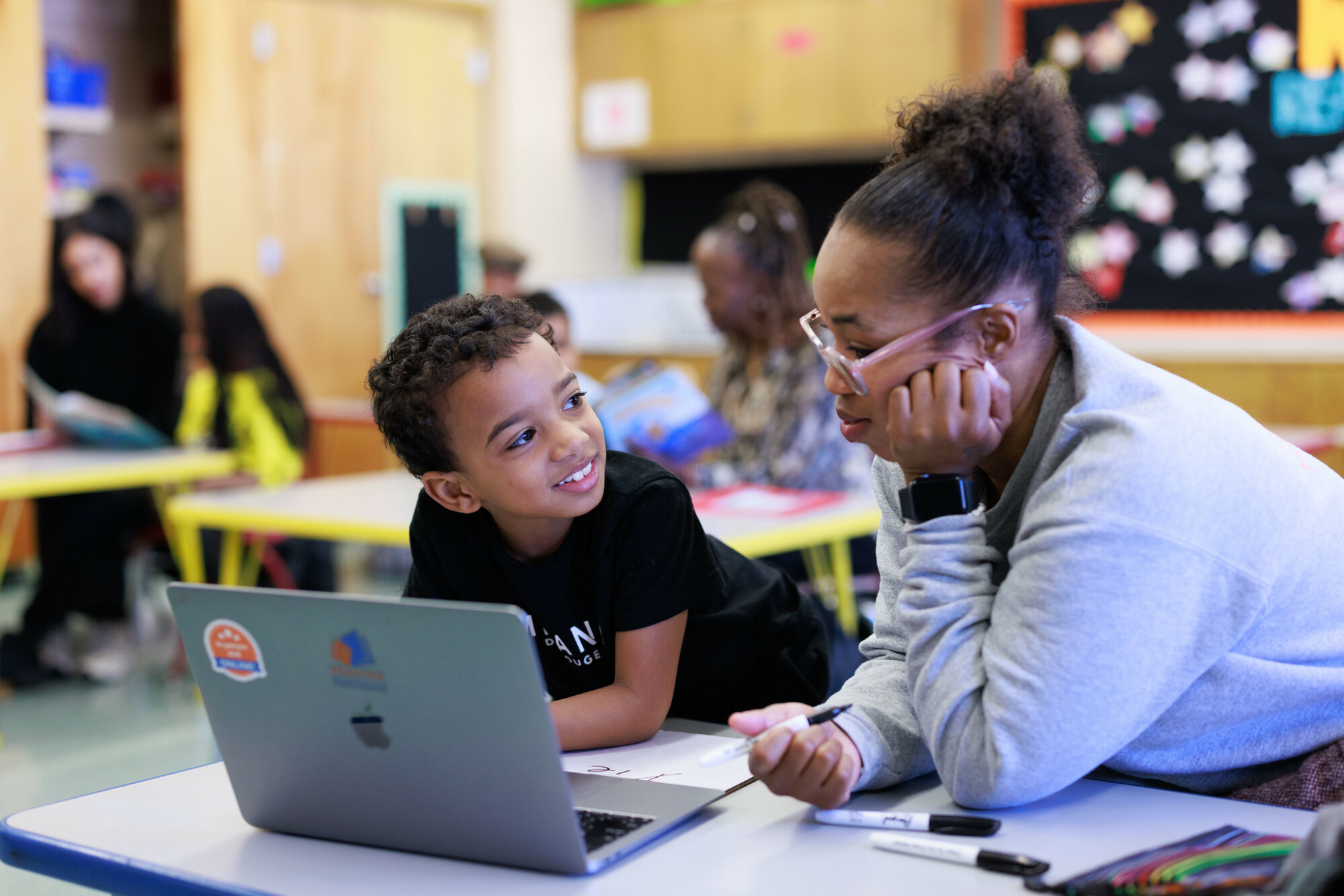 a tutor-student pair using reading partners connects, our innovation, on a computer in a reading center