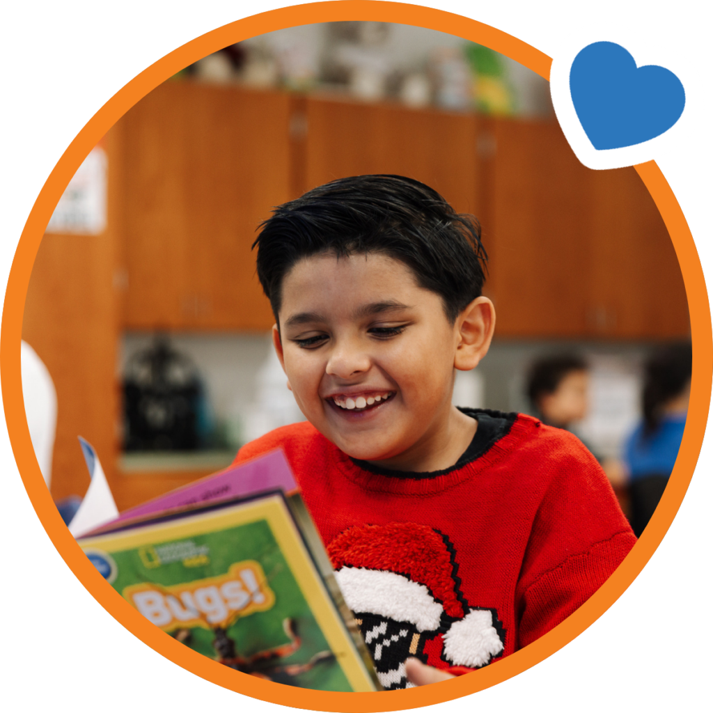 male students reading a book and smiling