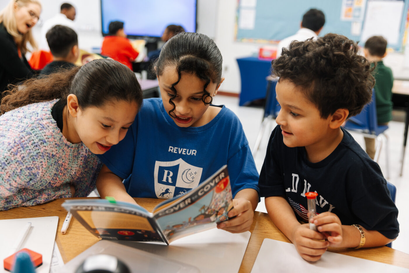 three students reading a cover to cover book