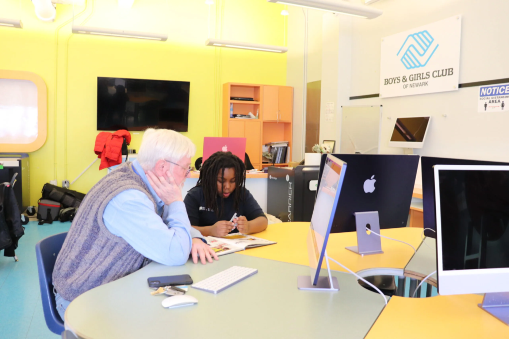 Free Virtual Tutoring in newark; a student and tutor sit at a computer while the student boosts their literacy skills